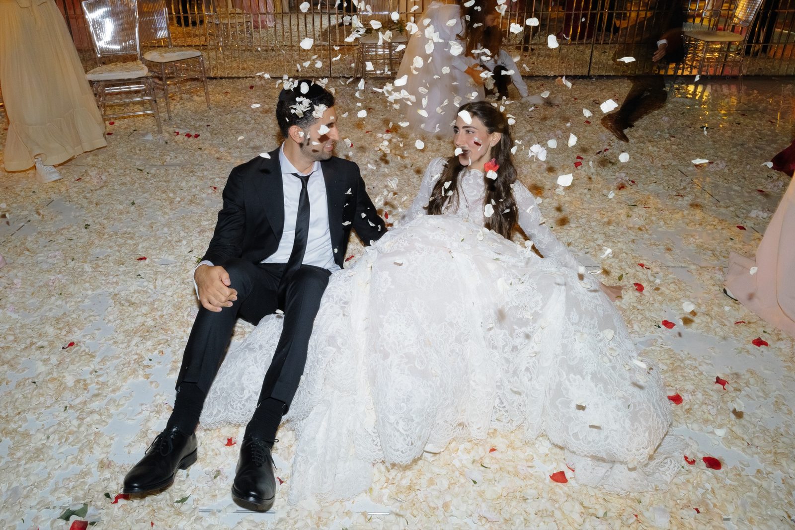 Adina and David sitting in the petals at the end of the night