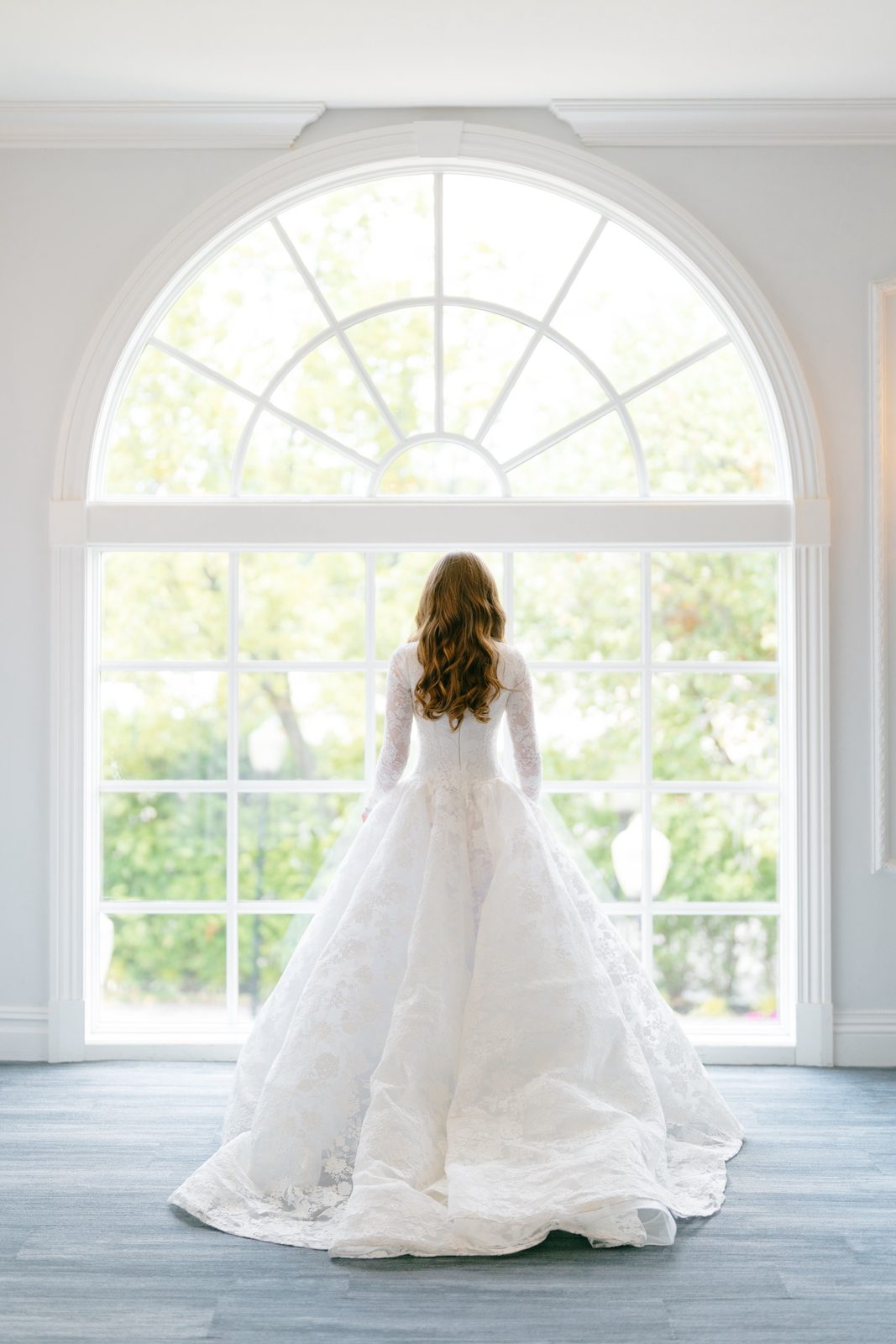 Atara in her gown at the arched window of the bridal suite