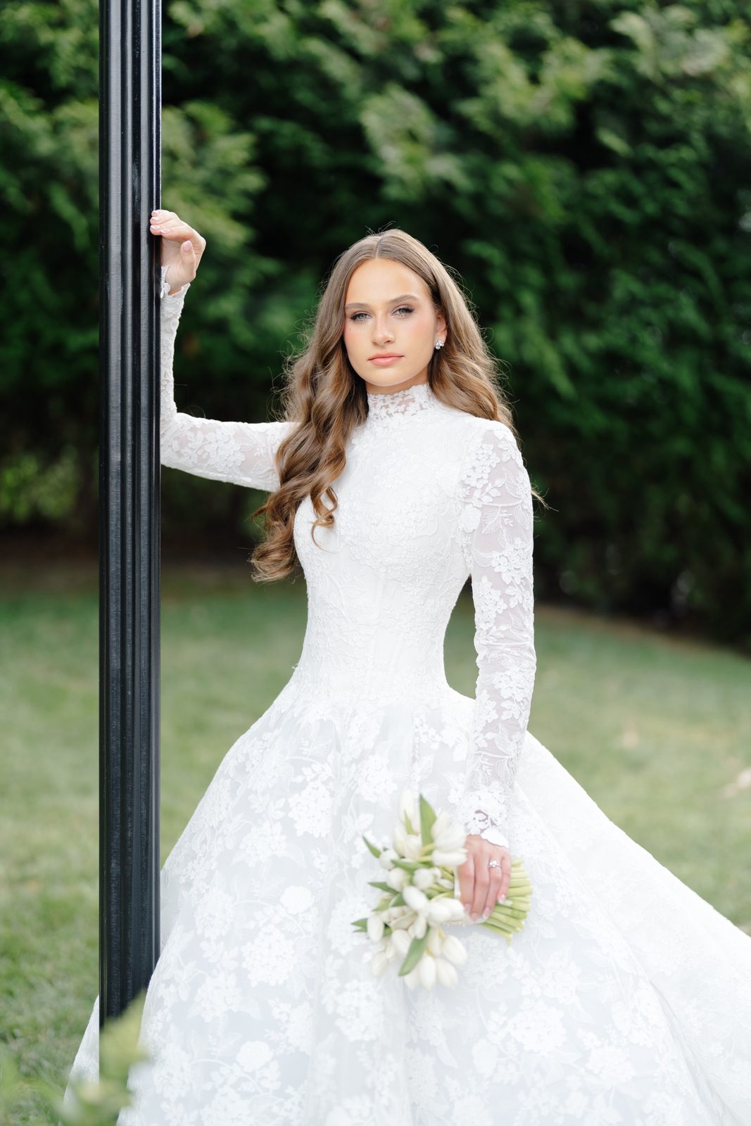 Atara with her bouquet by a lamppost in the gardens