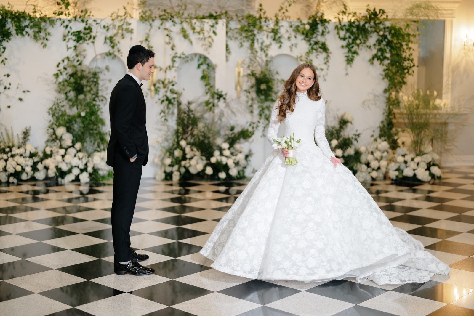 Atara and Ezra in the white floral room on the checkerboard floor