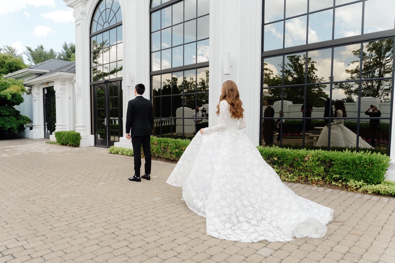 Atara walking toward Ezra for their first look in the courtyard at The Addison Park
