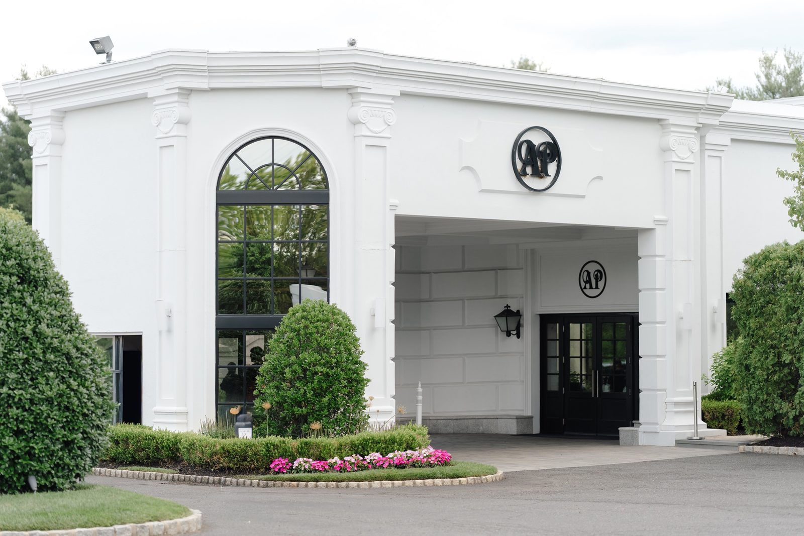 The white facade and arched entrance of The Addison Park in Aberdeen, New Jersey