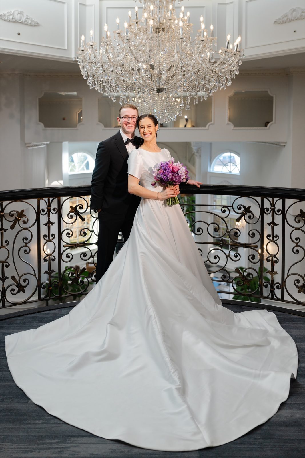 Kayla and Gabriel on the balcony under the crystal chandelier