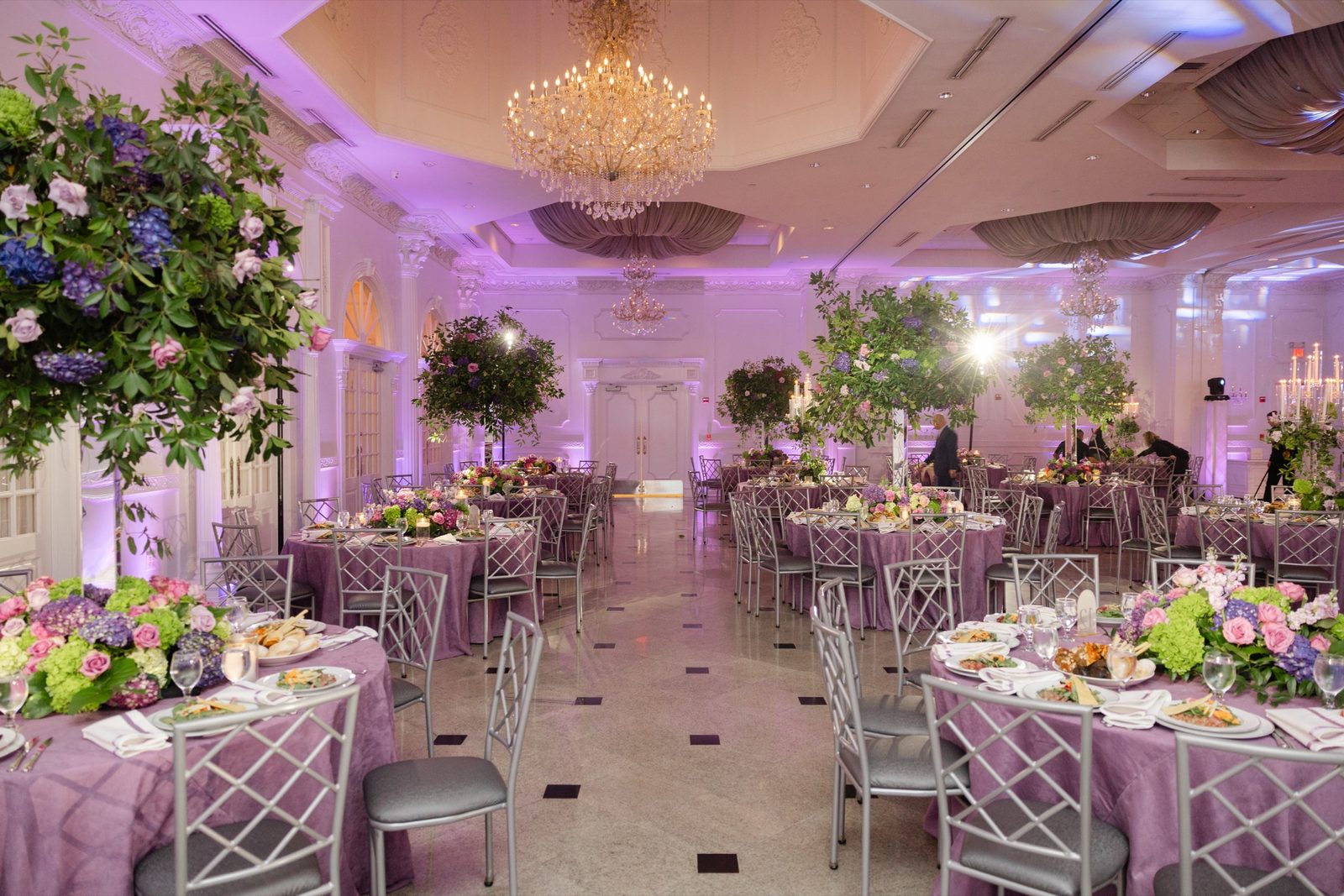 The ballroom at The Addison Park with purple uplighting and tree centerpieces