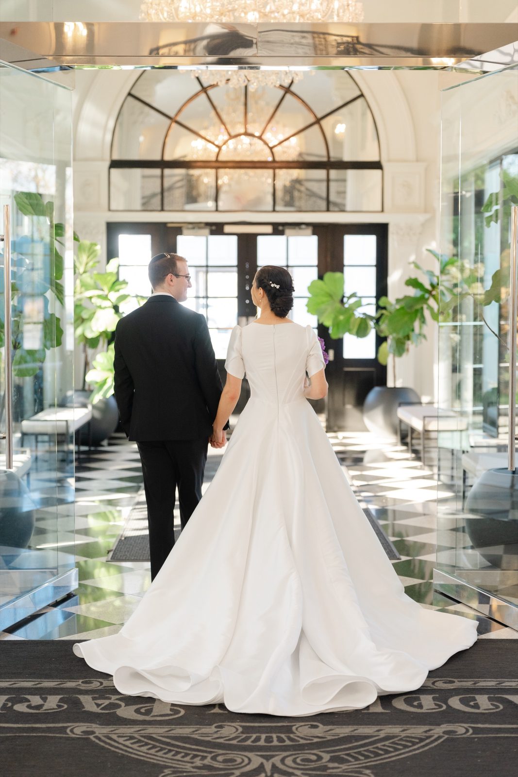 Kayla and Gabriel in the foyer, seen from behind