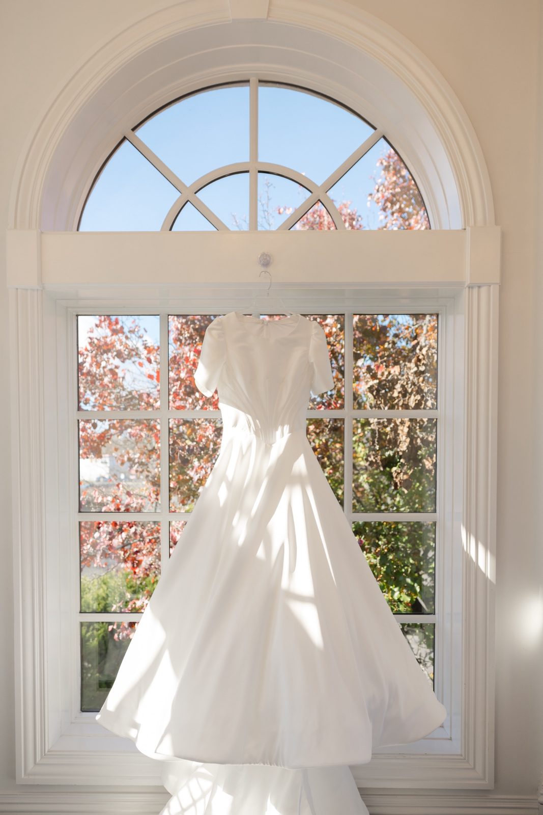 Kayla’s gown hanging in the arched window at The Addison Park