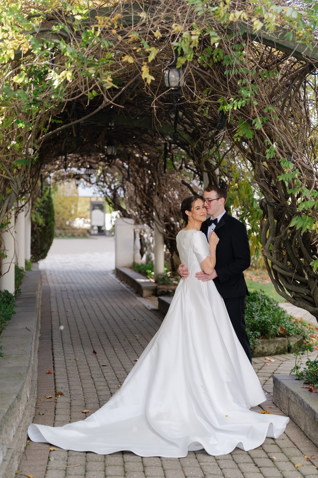 Kayla and Gabriel under the vine arbor walkway at The Addison Park