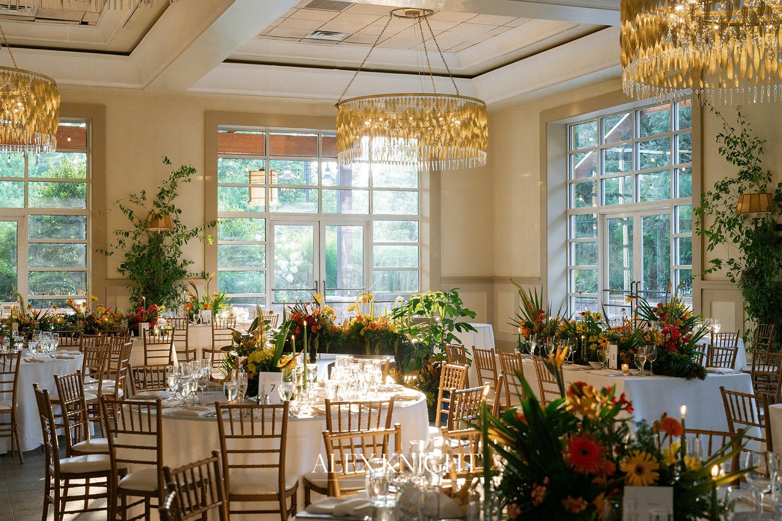 The reception room set with orange and yellow florals and crystal chandeliers