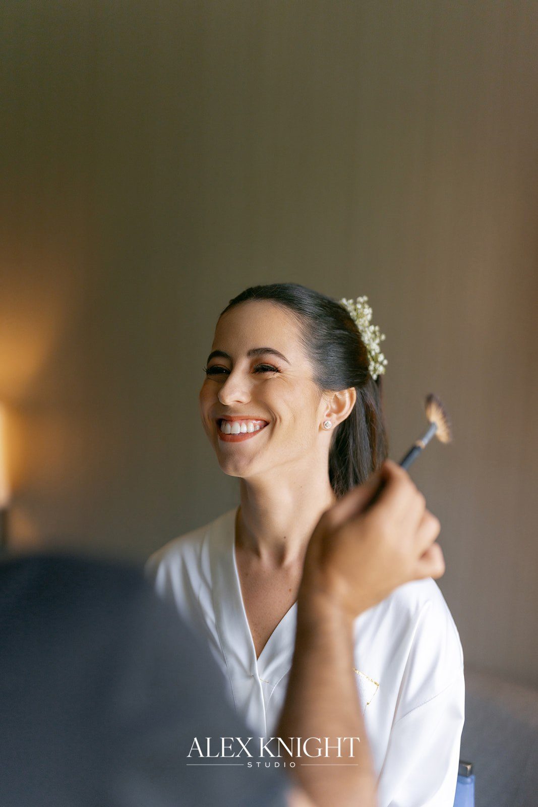 Aline laughing in the chair during hair and makeup