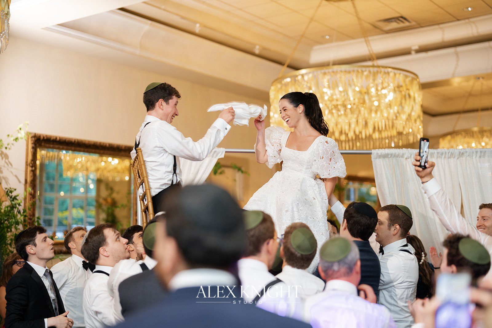 Aline and Tyler lifted on chairs during the hora