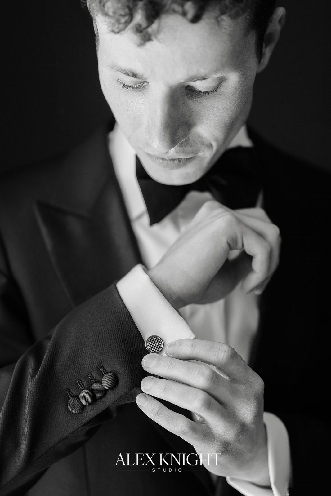 Tyler fastening his cufflinks, in black and white