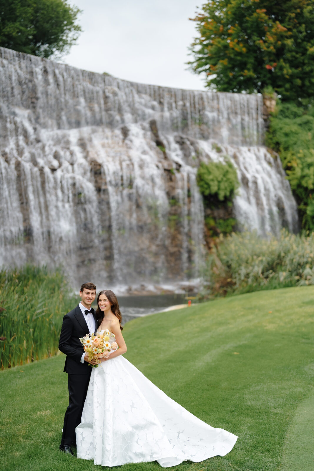 Allie and Charlie in front of the waterfall at Trump National Golf Club Westchester