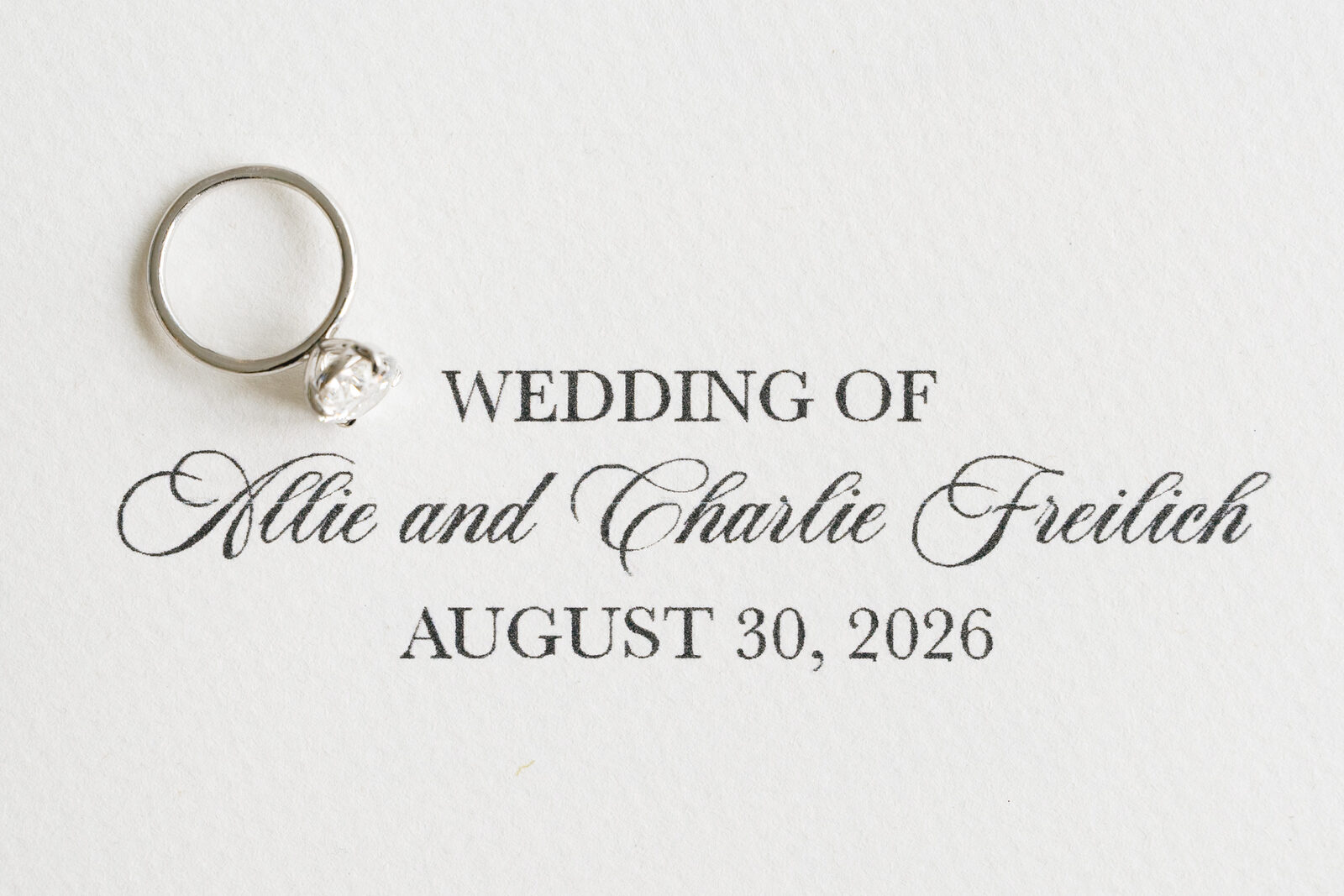 Allie and Charlie Freilich's wedding invitation with their rings, August 30, 2026