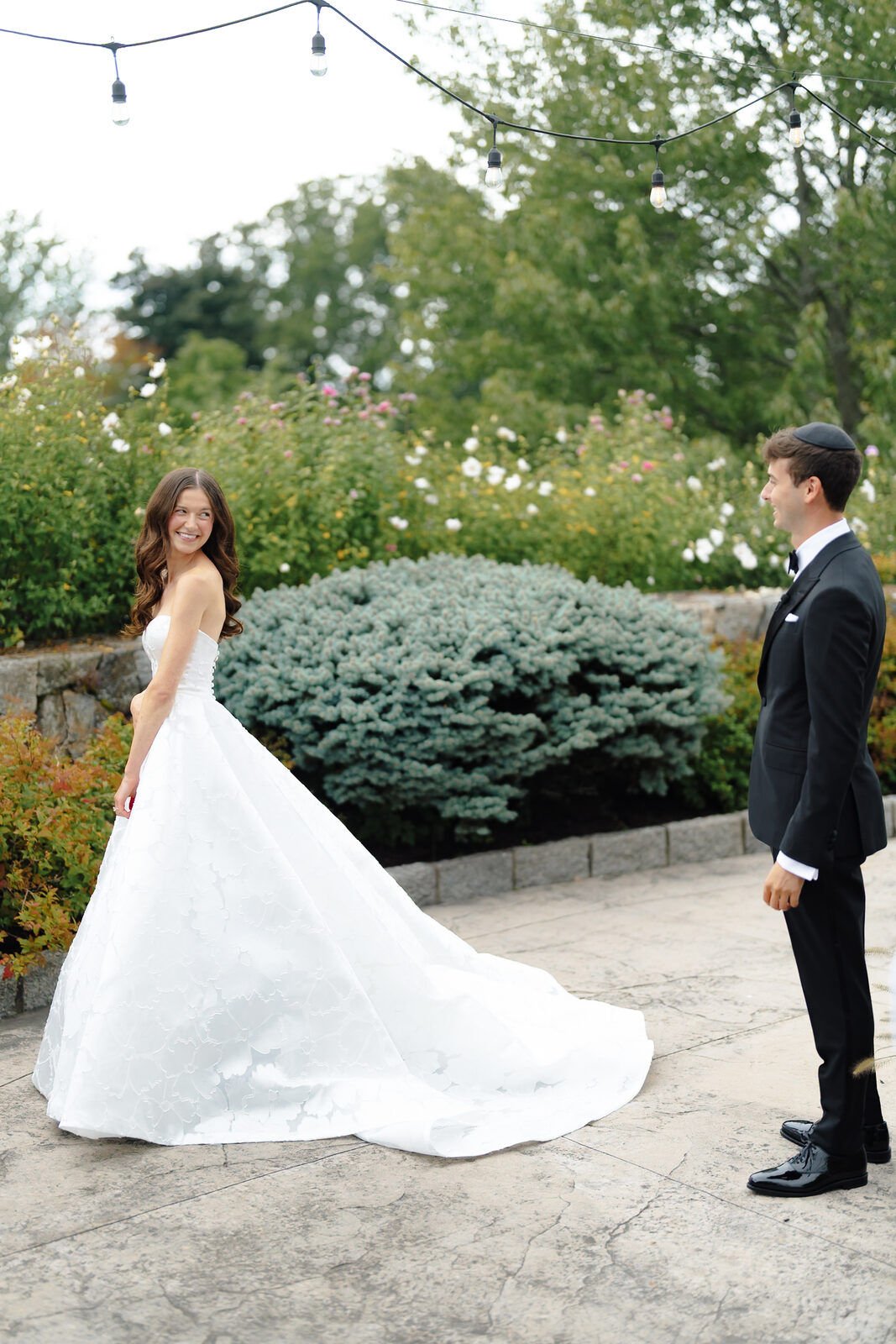 Allie twirls in her gown on the garden path, Charlie watching