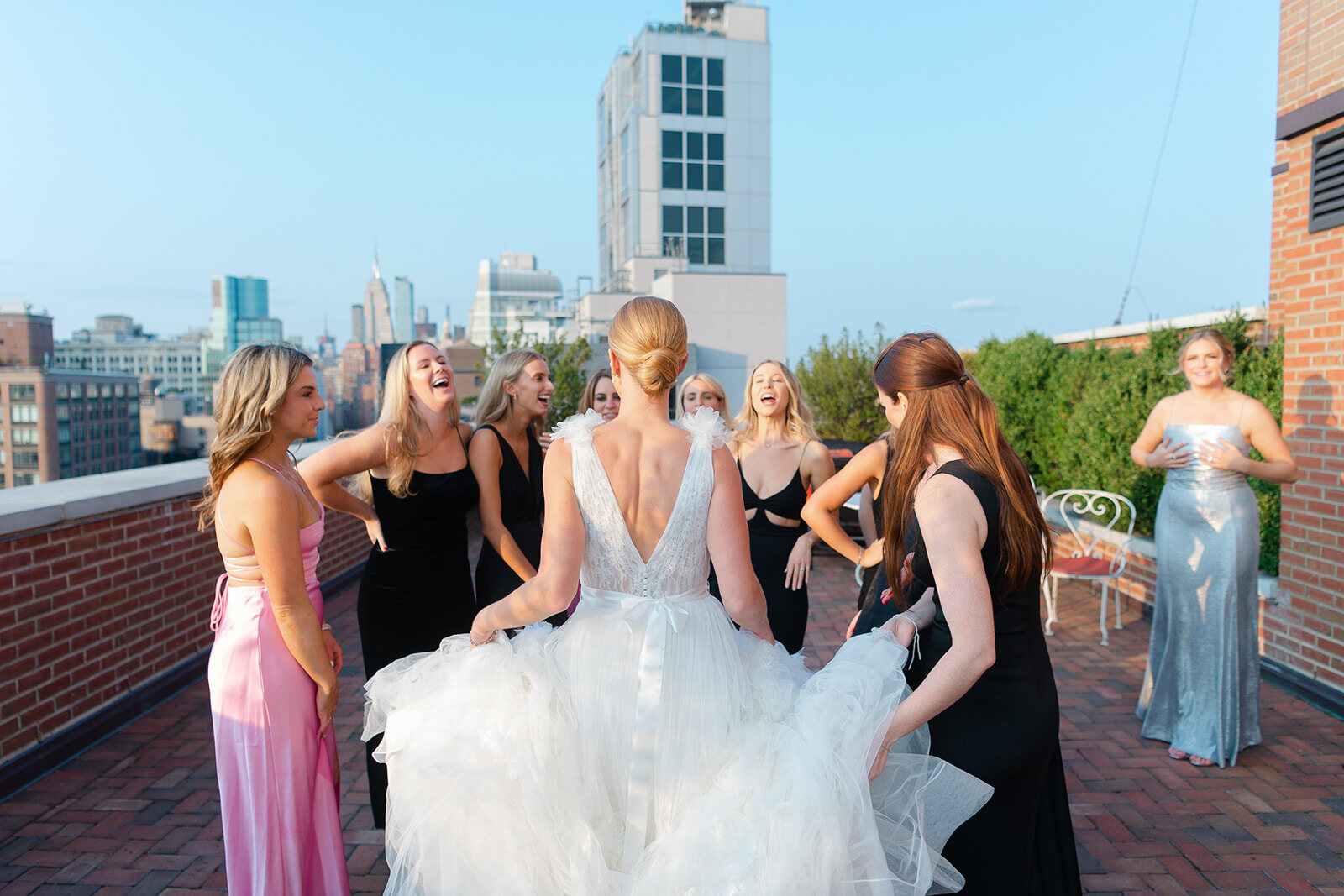 Ashley laughs with her bridesmaids on the rooftop terrace