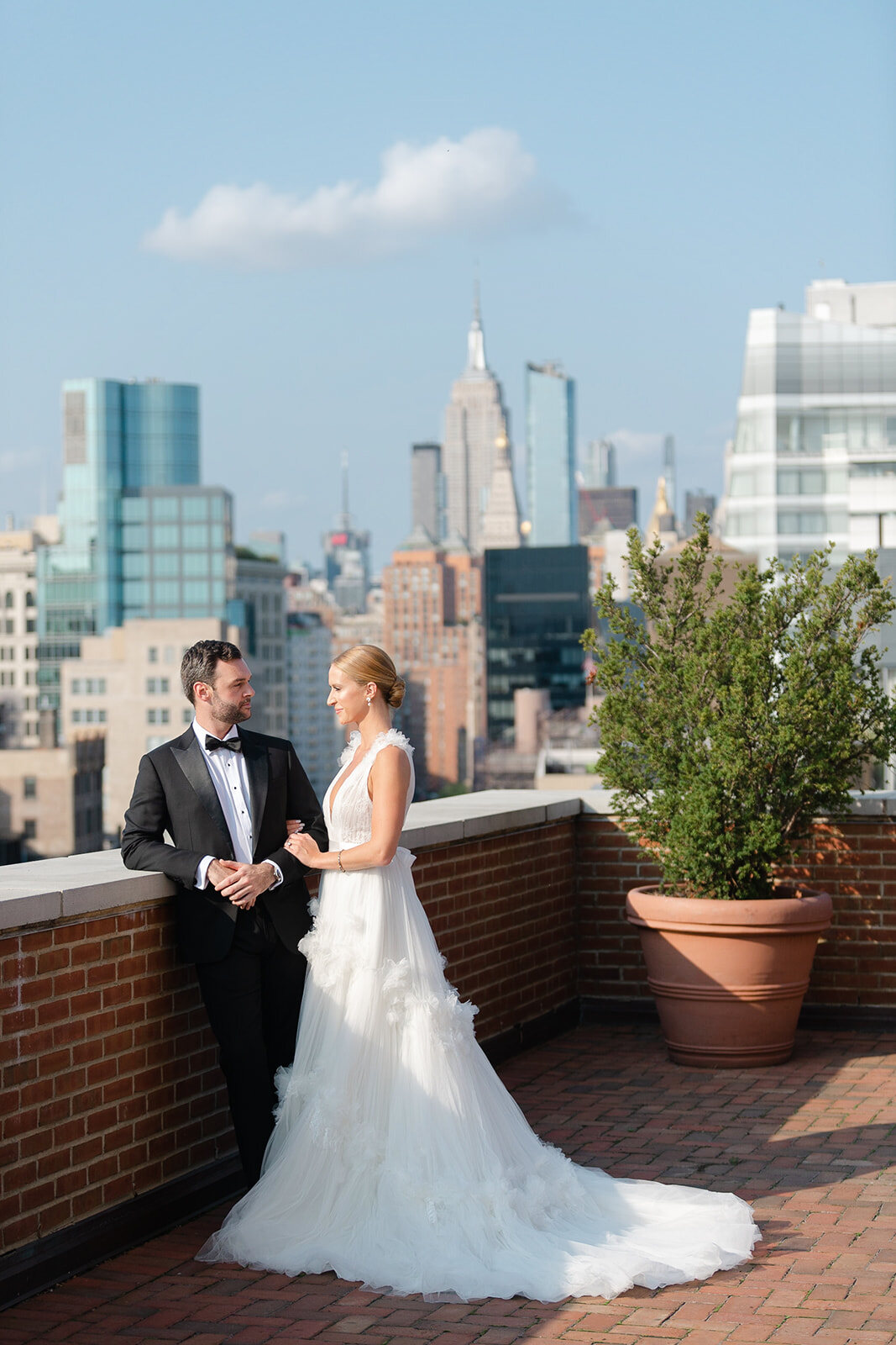 Ashley and Kendall on the brick terrace among potted trees and rooftops