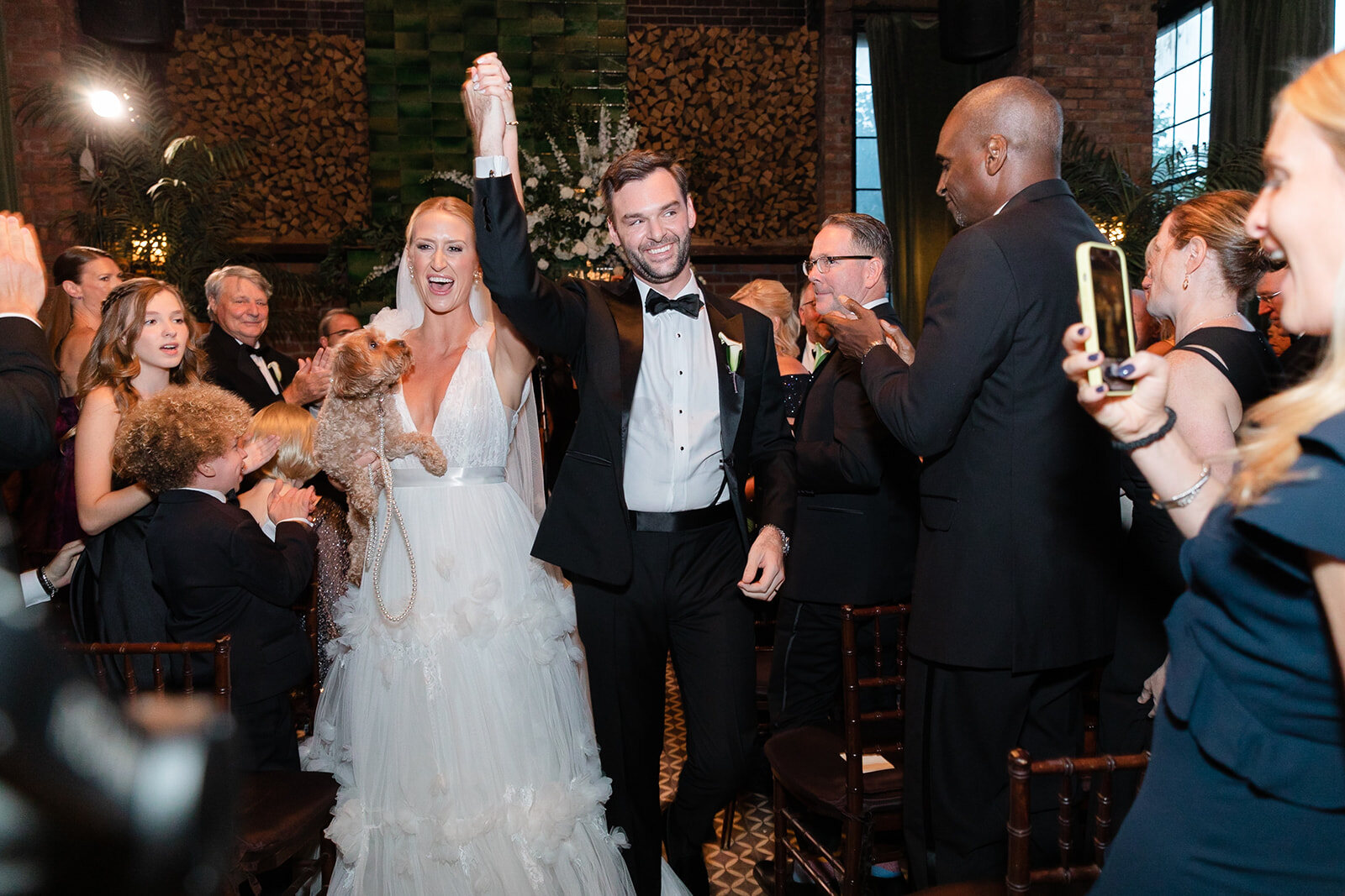 Ashley and Kendall walk back up the aisle as guests celebrate
