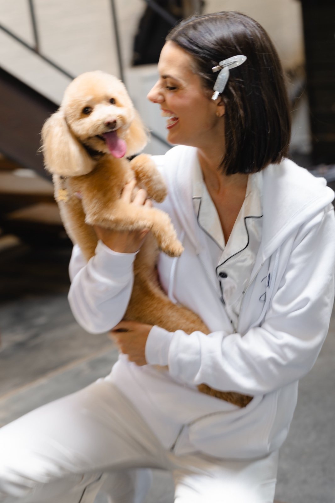 Daniella in white satin pajamas with her dog