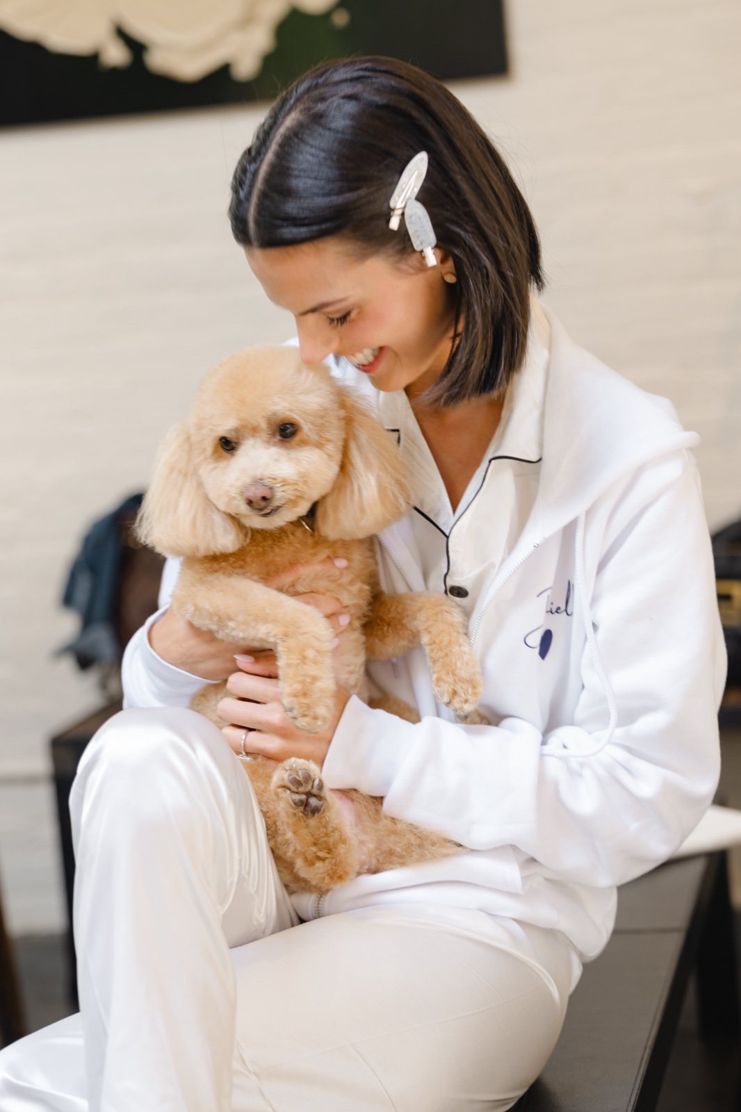 Her dog in her arms while getting ready