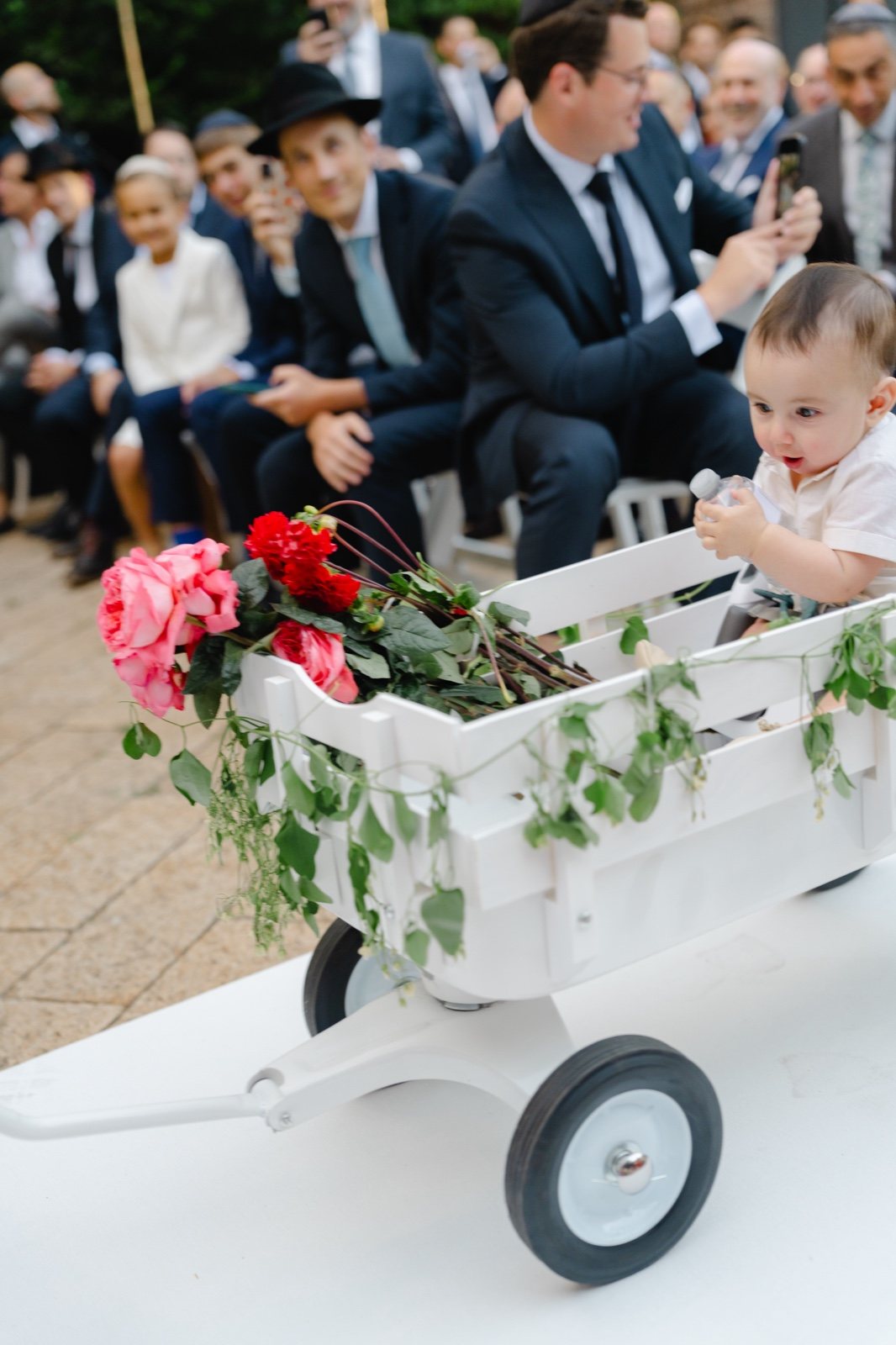 The dog rides down the aisle in a flower cart