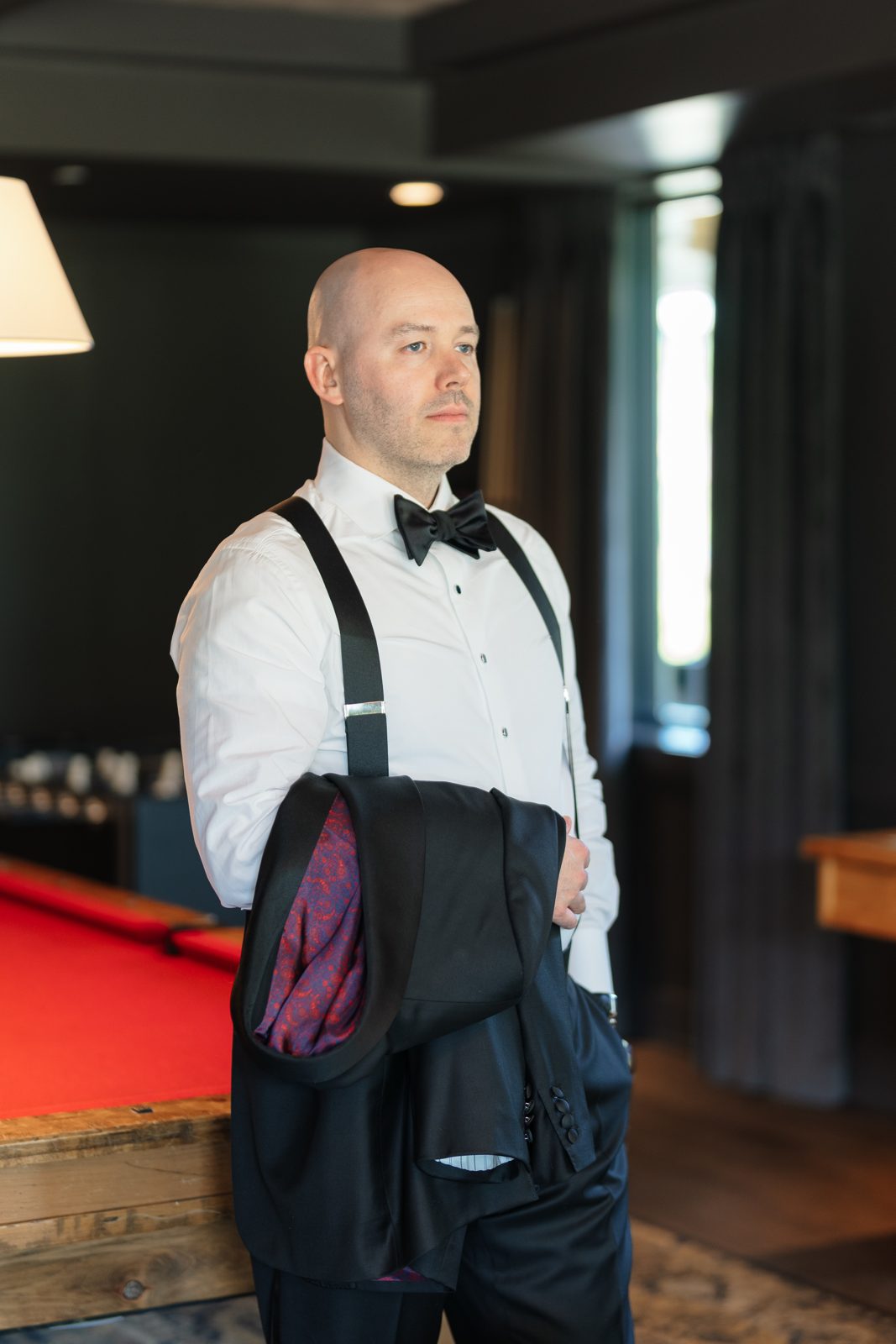 Casey getting ready with his jacket over his shoulder in the billiards room