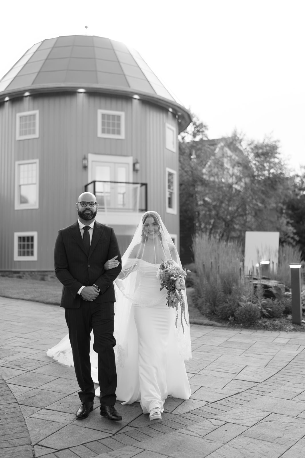 The outdoor ceremony at Bear Brook Valley under a pergola of pink and coral florals