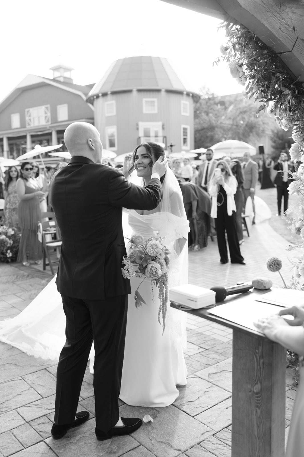 The outdoor ceremony at Bear Brook Valley under a pergola of pink and coral florals