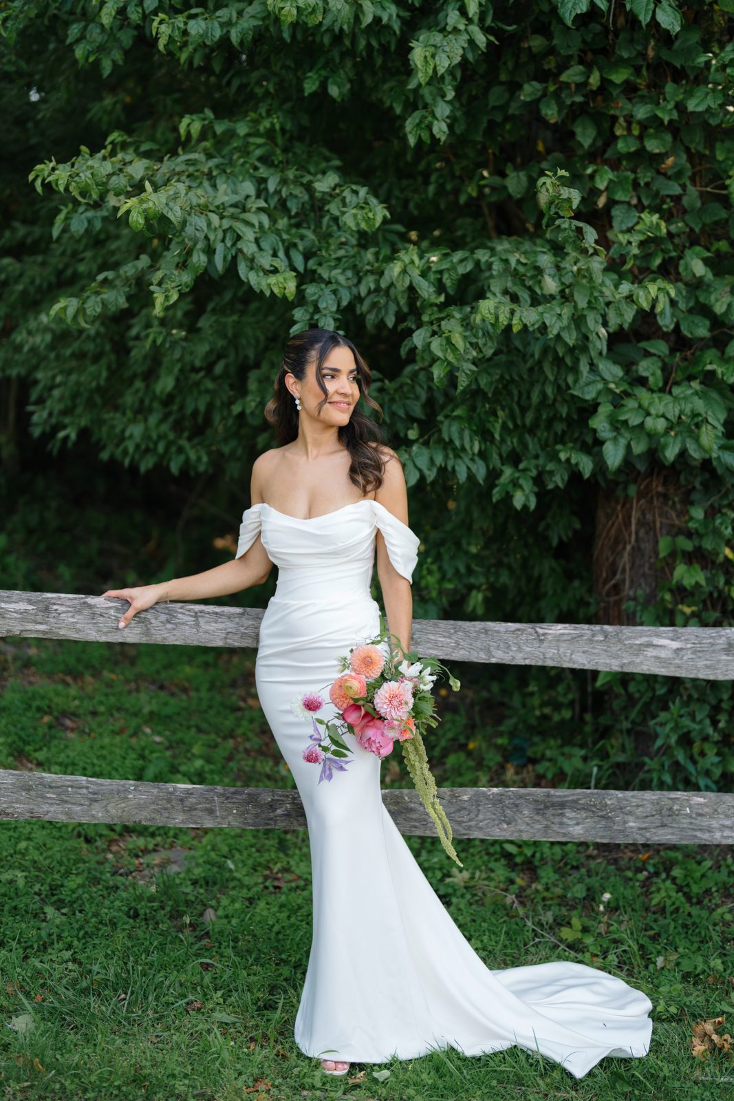 Dharma with her bouquet along a split-rail fence