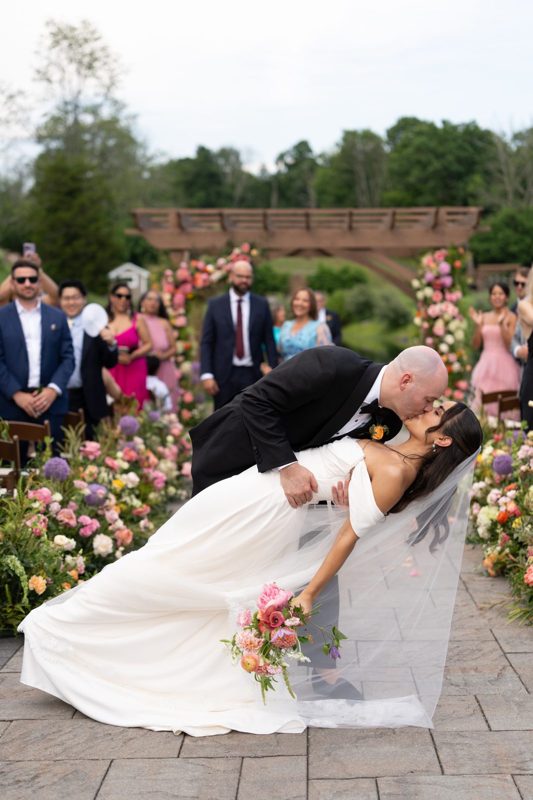 Casey dips Dharma for a kiss at the floral-covered arch