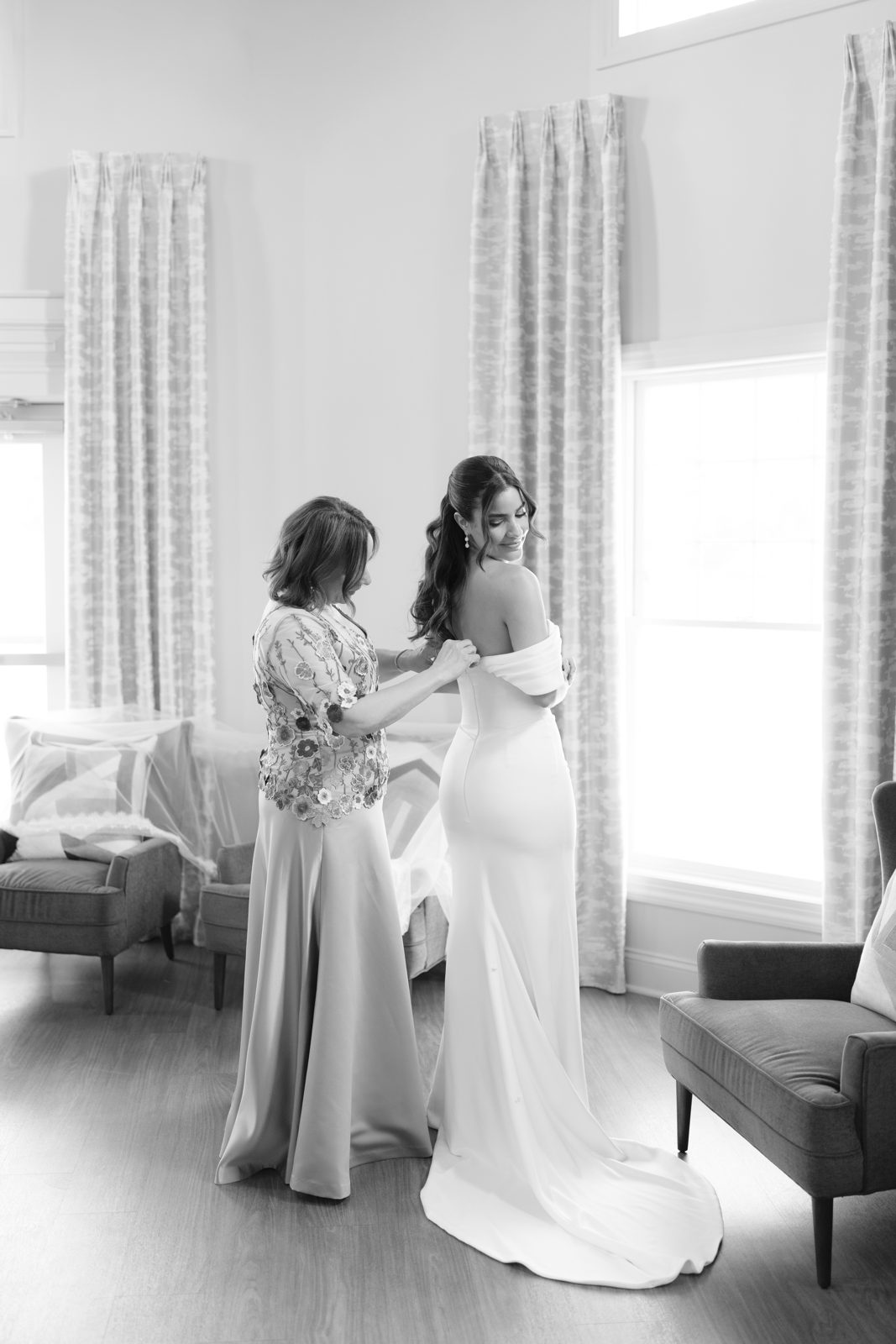 Final touches on the gown in the bridal suite window light