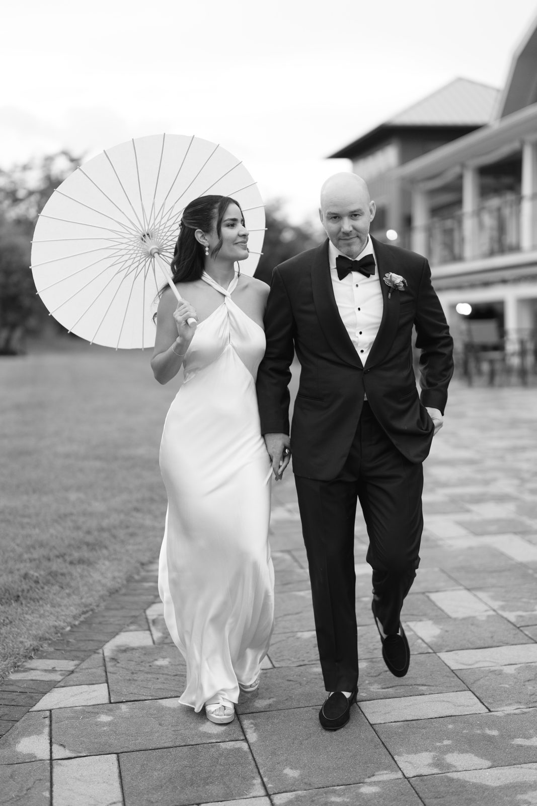 Dharma twirls a white parasol as she and Casey stroll the grounds