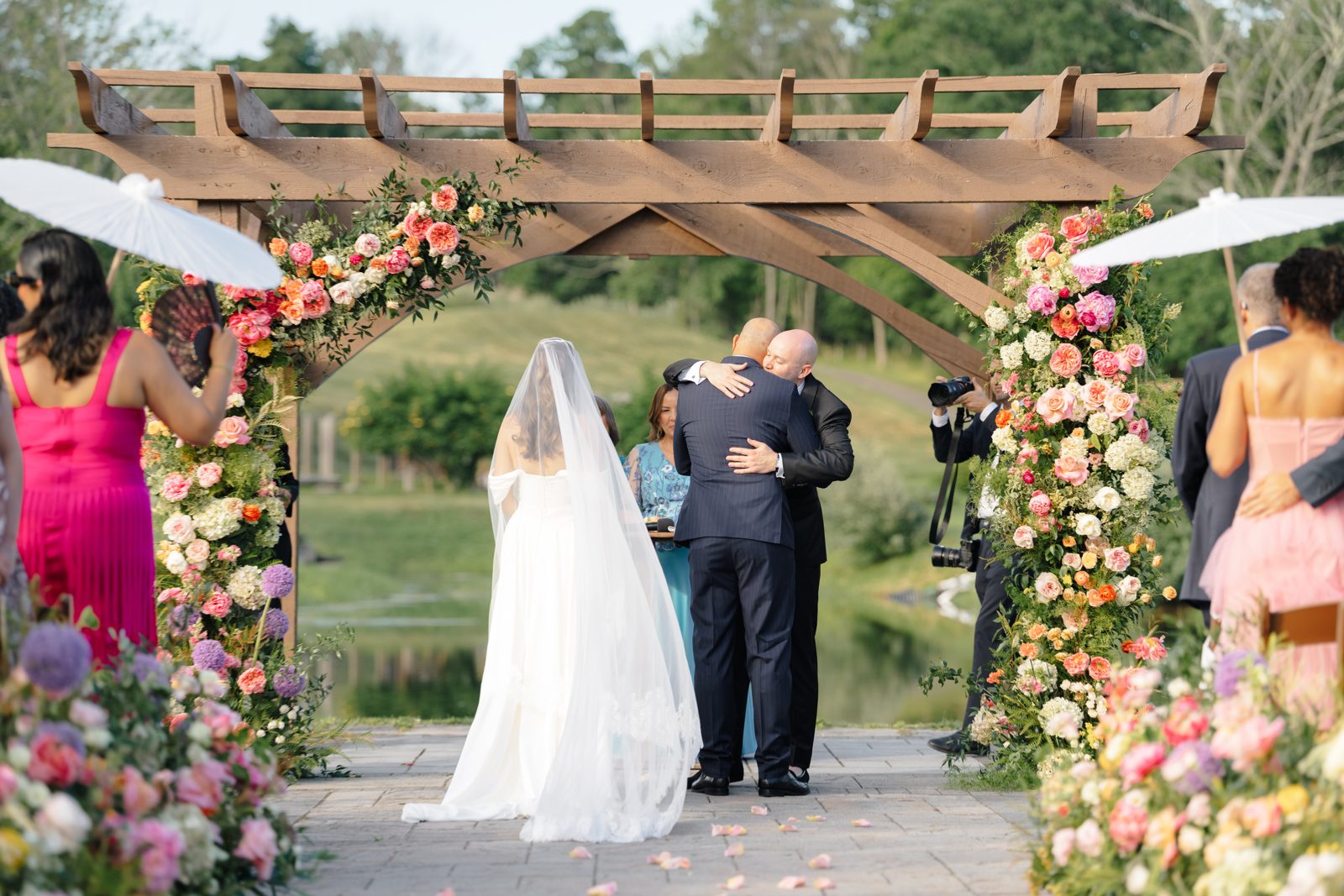 The processional arrives at the flower-covered pergola