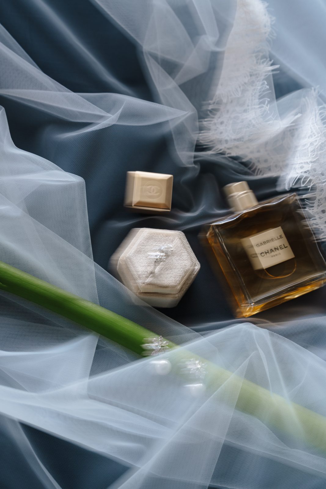 Rings and perfume resting on the veil