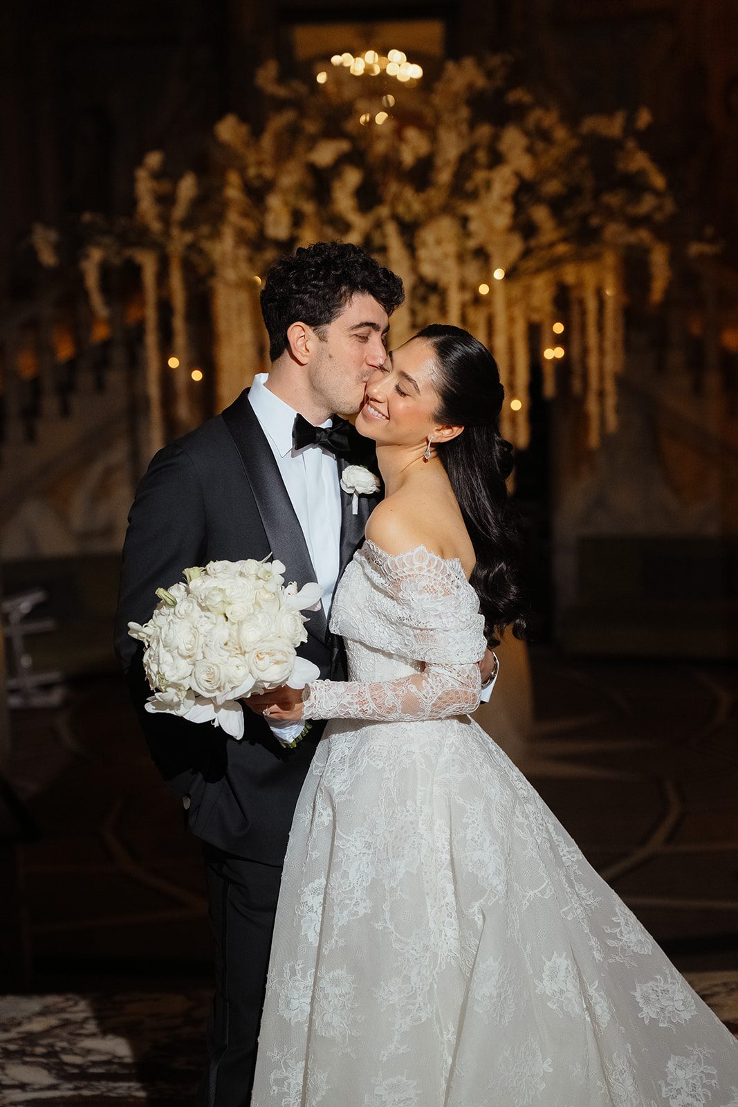 Ben kisses Dori beside the ceremony florals at The Pierre