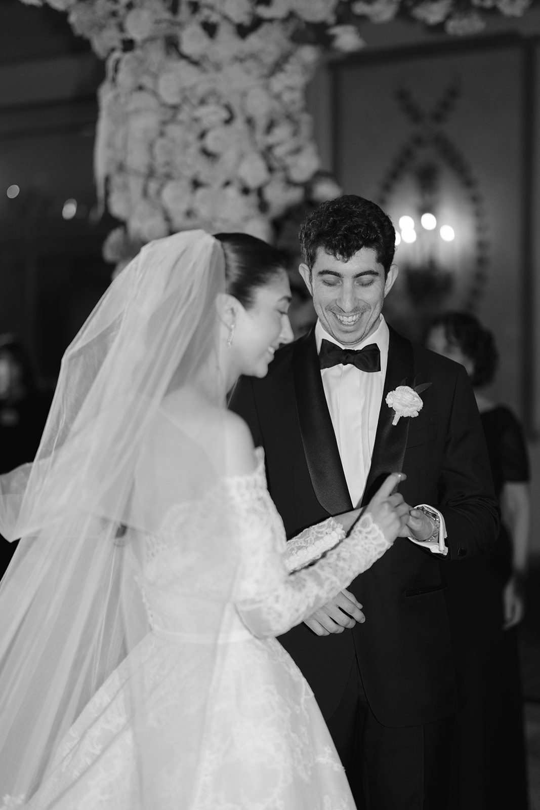 Dori and Ben laughing under the chuppah, black and white