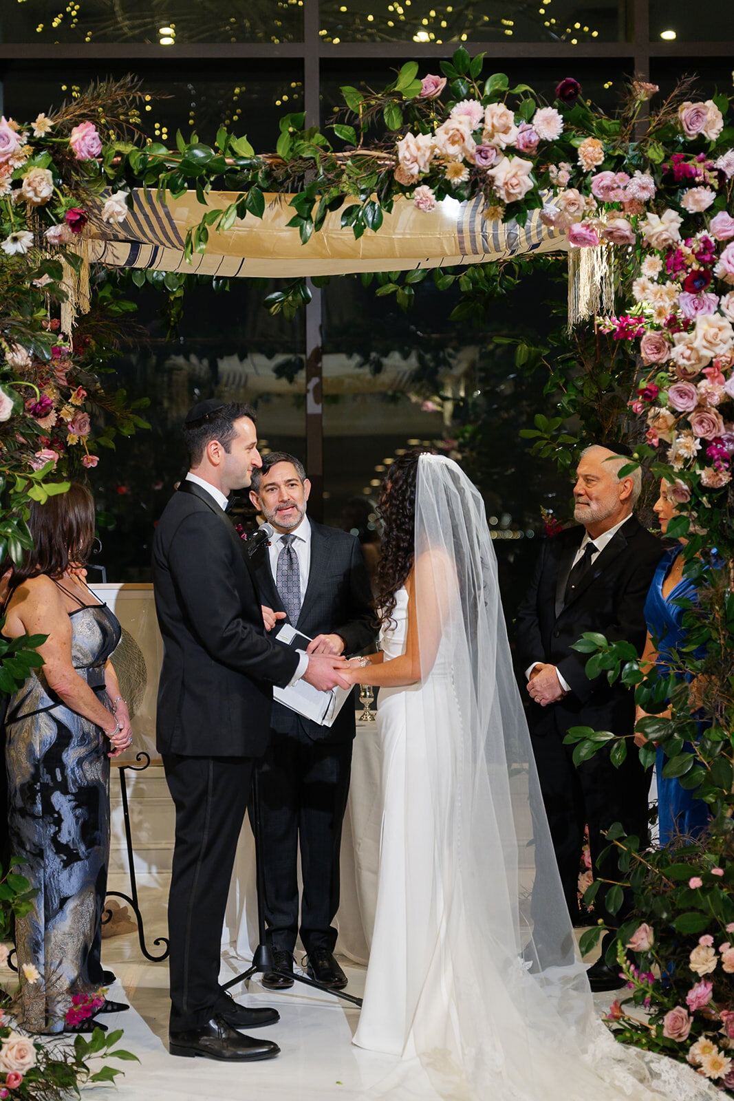 Ellie and Harrison under the chuppah of pink and white florals