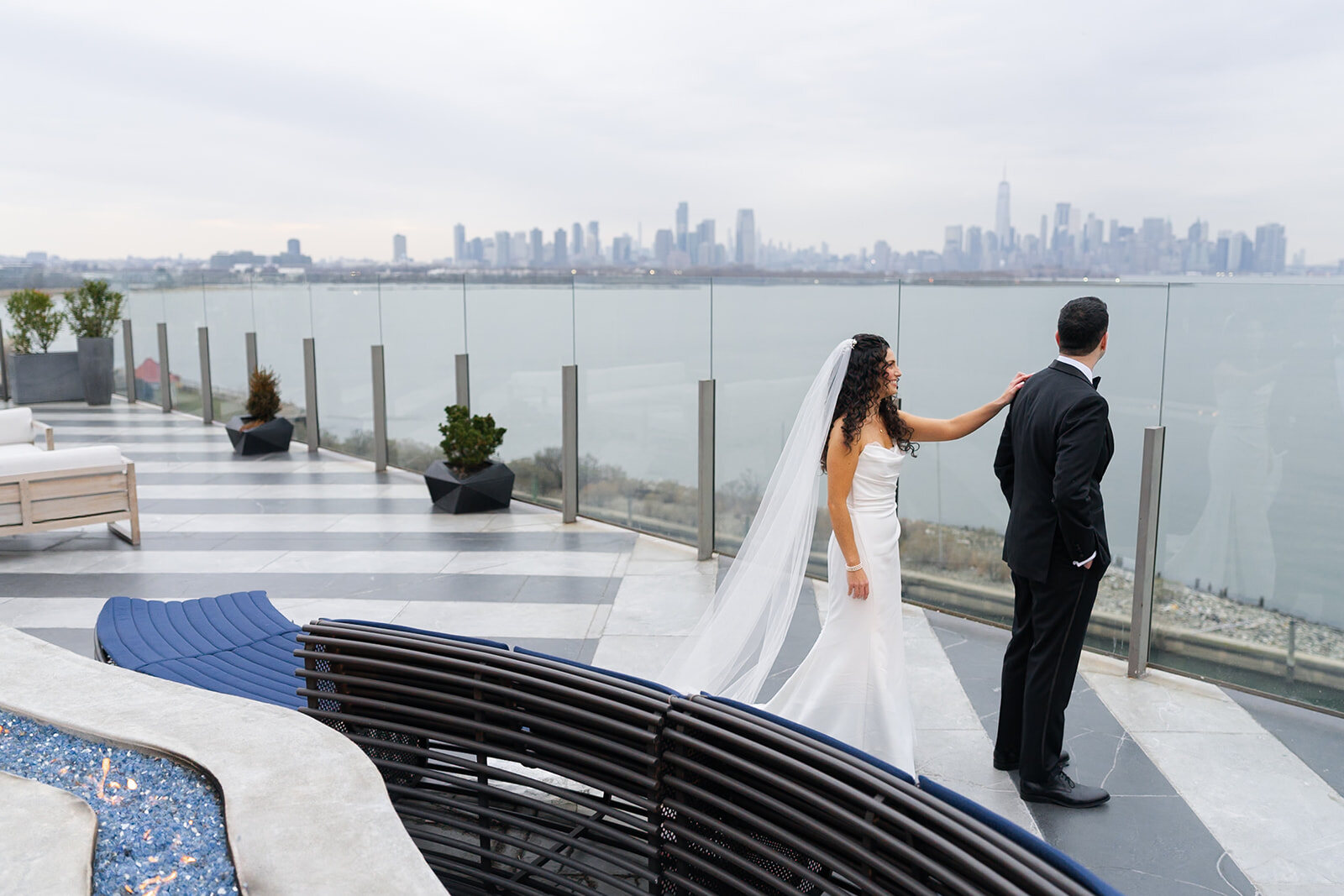 Ellie walks up to Harrison for their first look on the rooftop, Manhattan across the Hudson