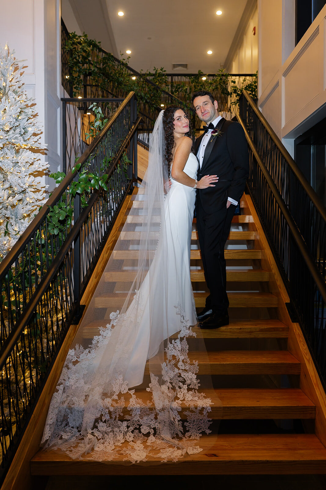 Ellie’s veil and train down the Hudson House staircase with Harrison at the top