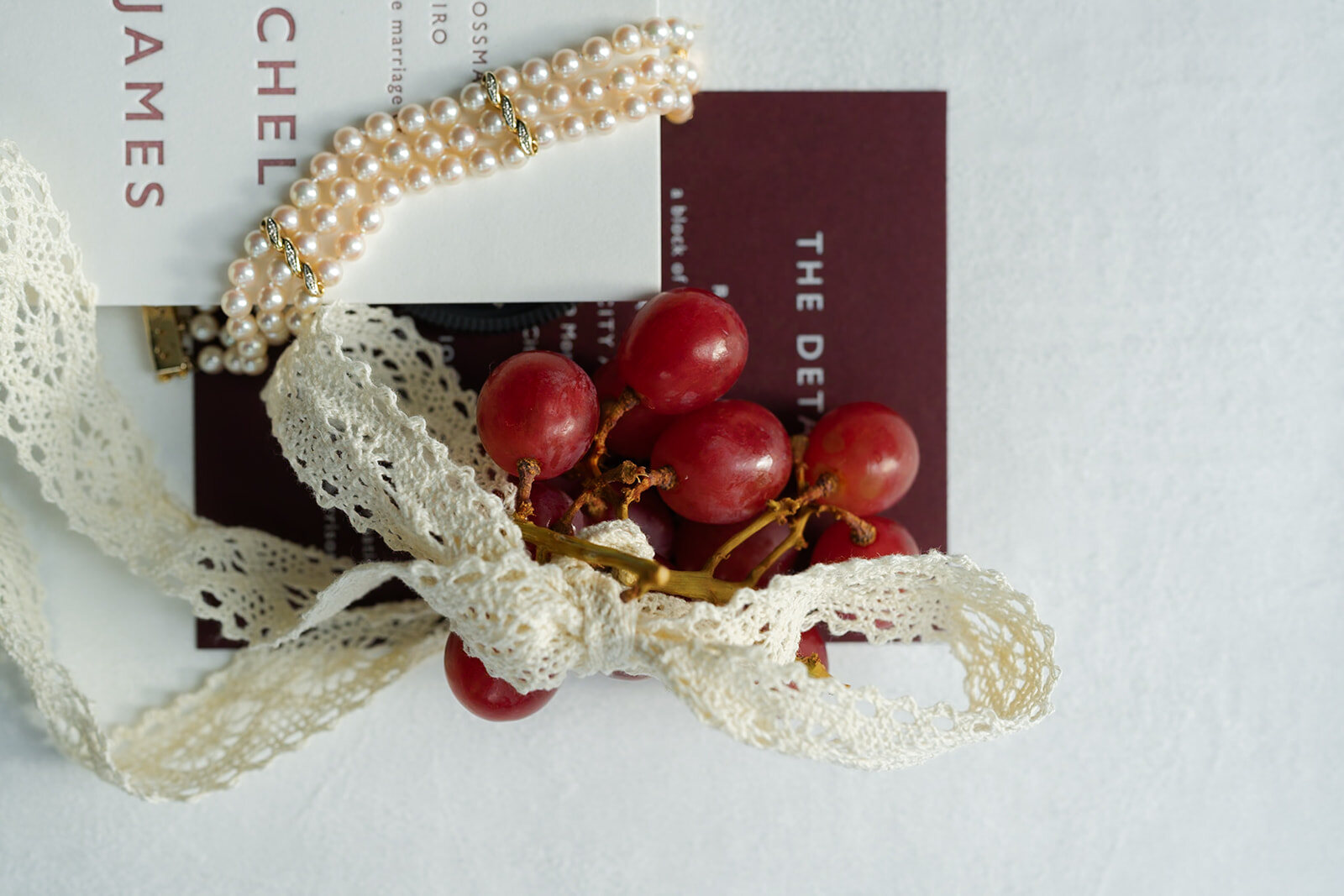 Pearls and ribbon with red cherries, the wedding colors in the details