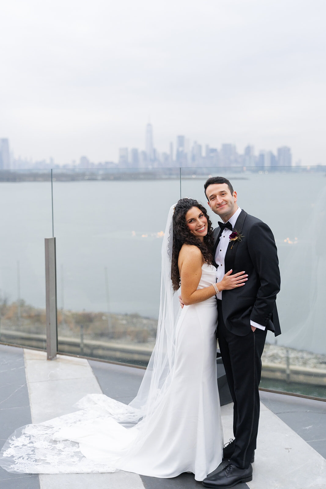 Ellie and Harrison on the rooftop terrace with the skyline behind them