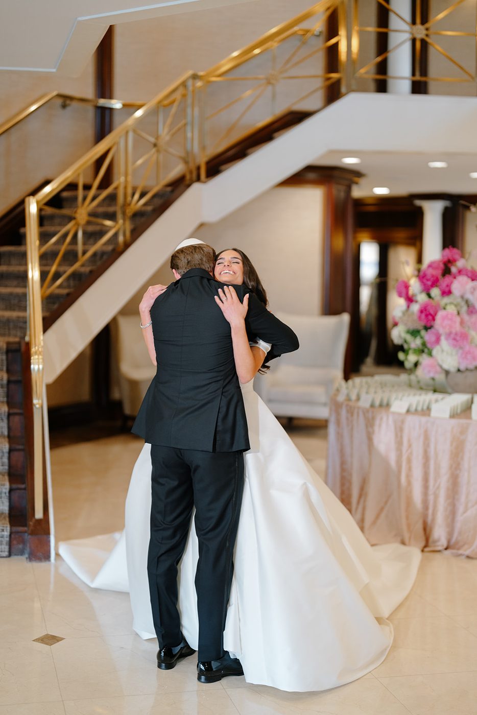 The couple embrace beneath the gold banister after seeing each other for the first time.