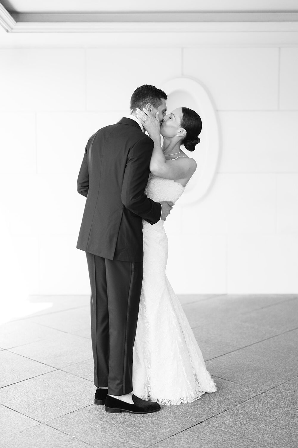 A black and white kiss in the mansion's white marble hallway.