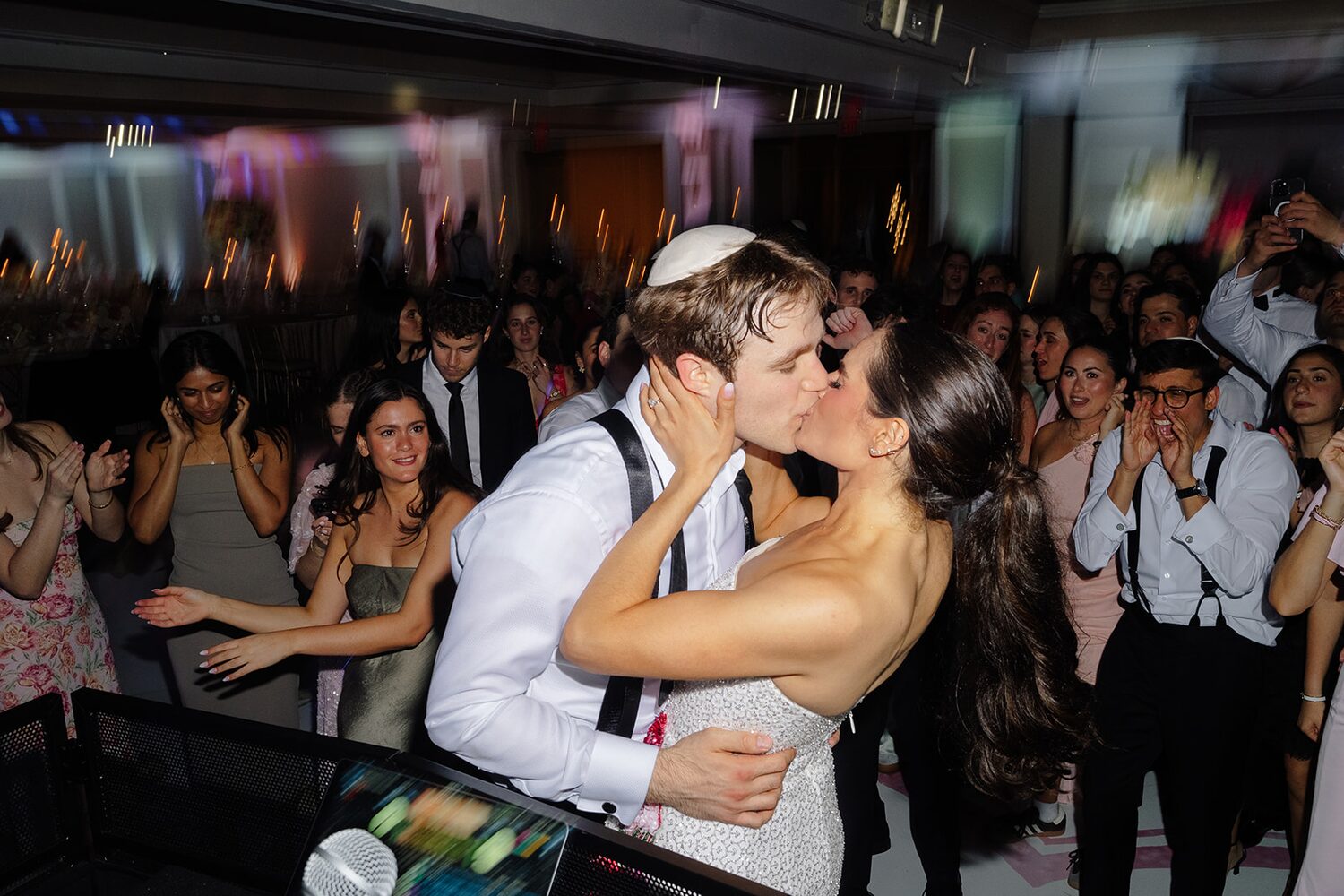 A kiss in the middle of the packed dance floor mid-celebration.