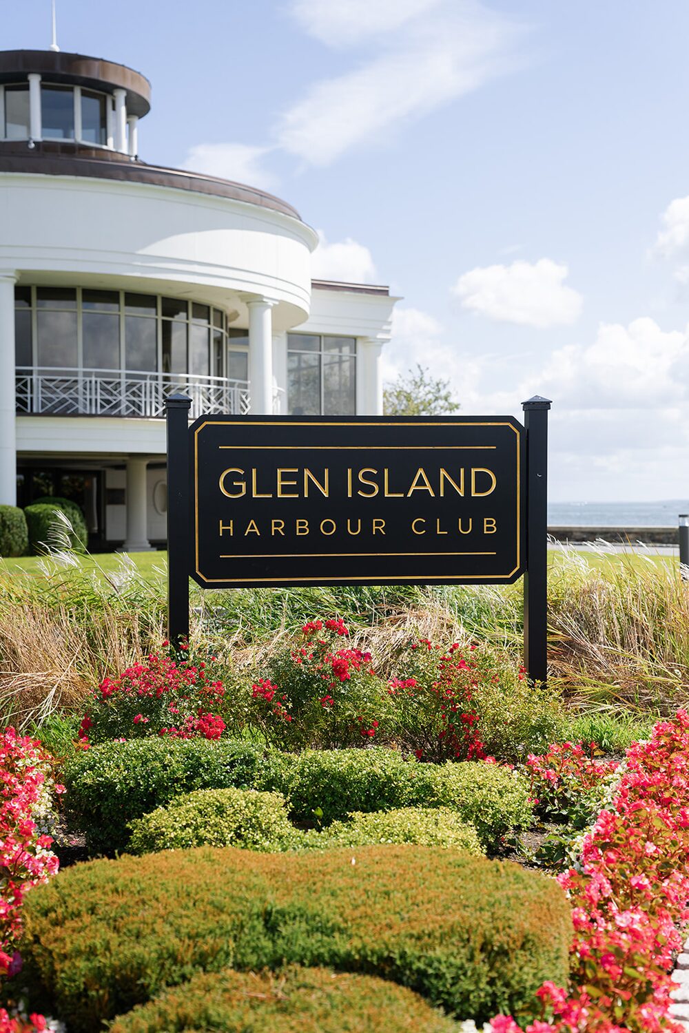 The Glen Island Harbour Club sign in its flower bed, the rotunda rising behind.