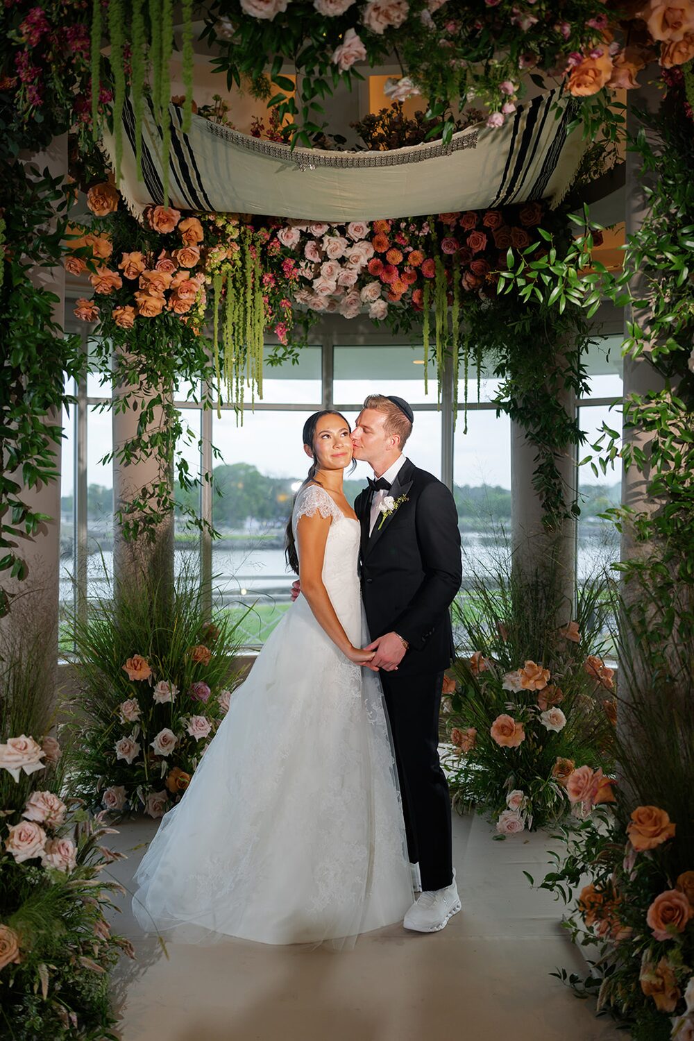 Lianne and Alec share their first married kiss beneath the rose chuppah.