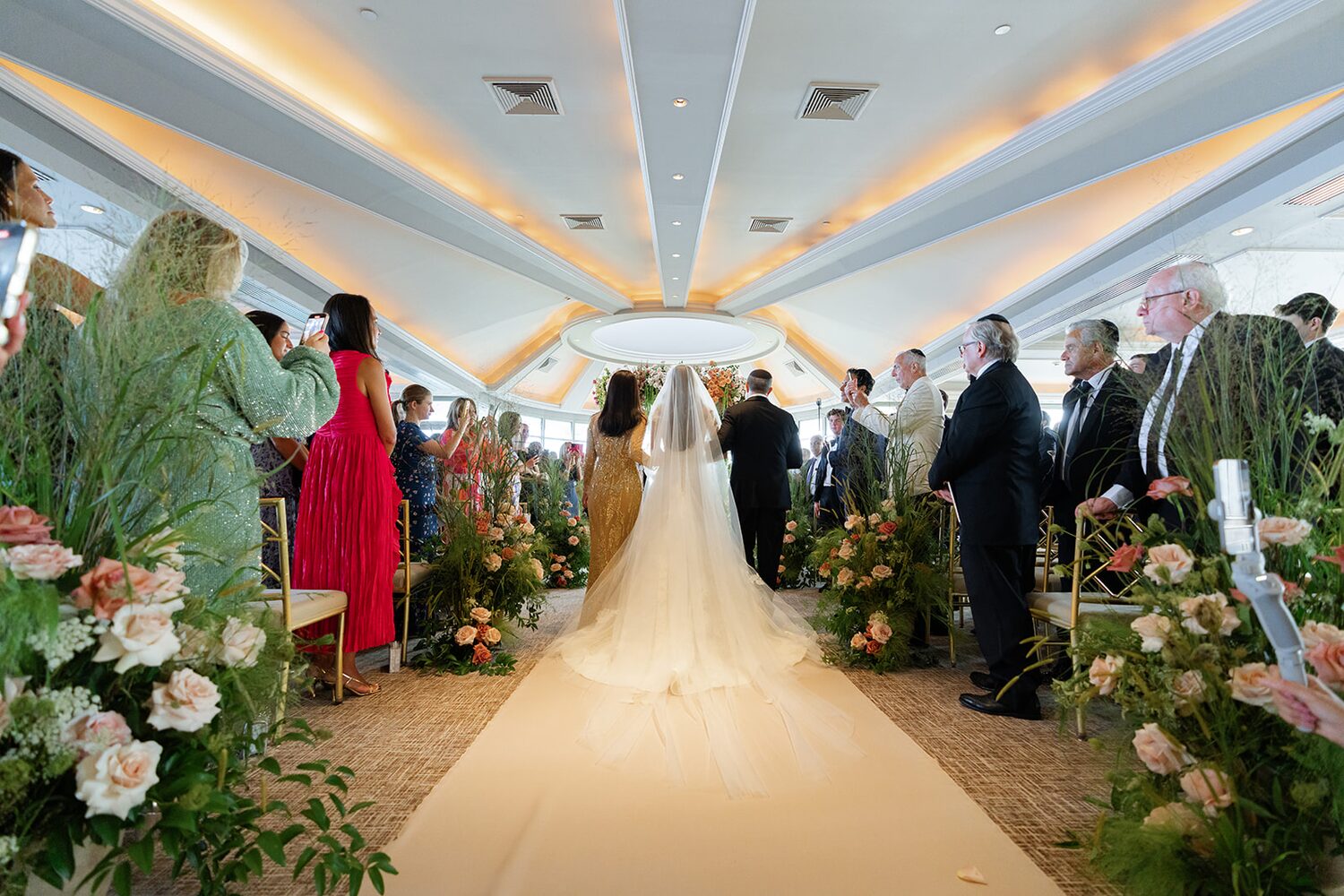 The newlyweds head back up the rose-lined aisle to cheers.