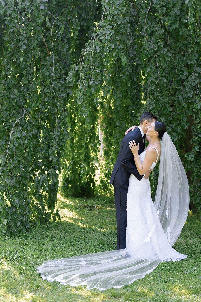 A kiss beneath the weeping willow, her beaded veil spread across the grass.