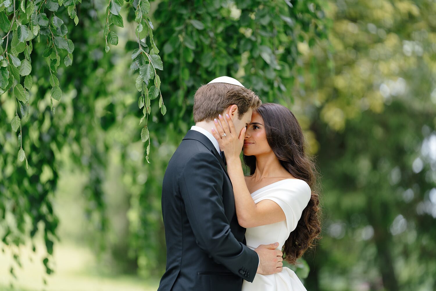 Beneath the willow canopy, the groom draws his bride close.