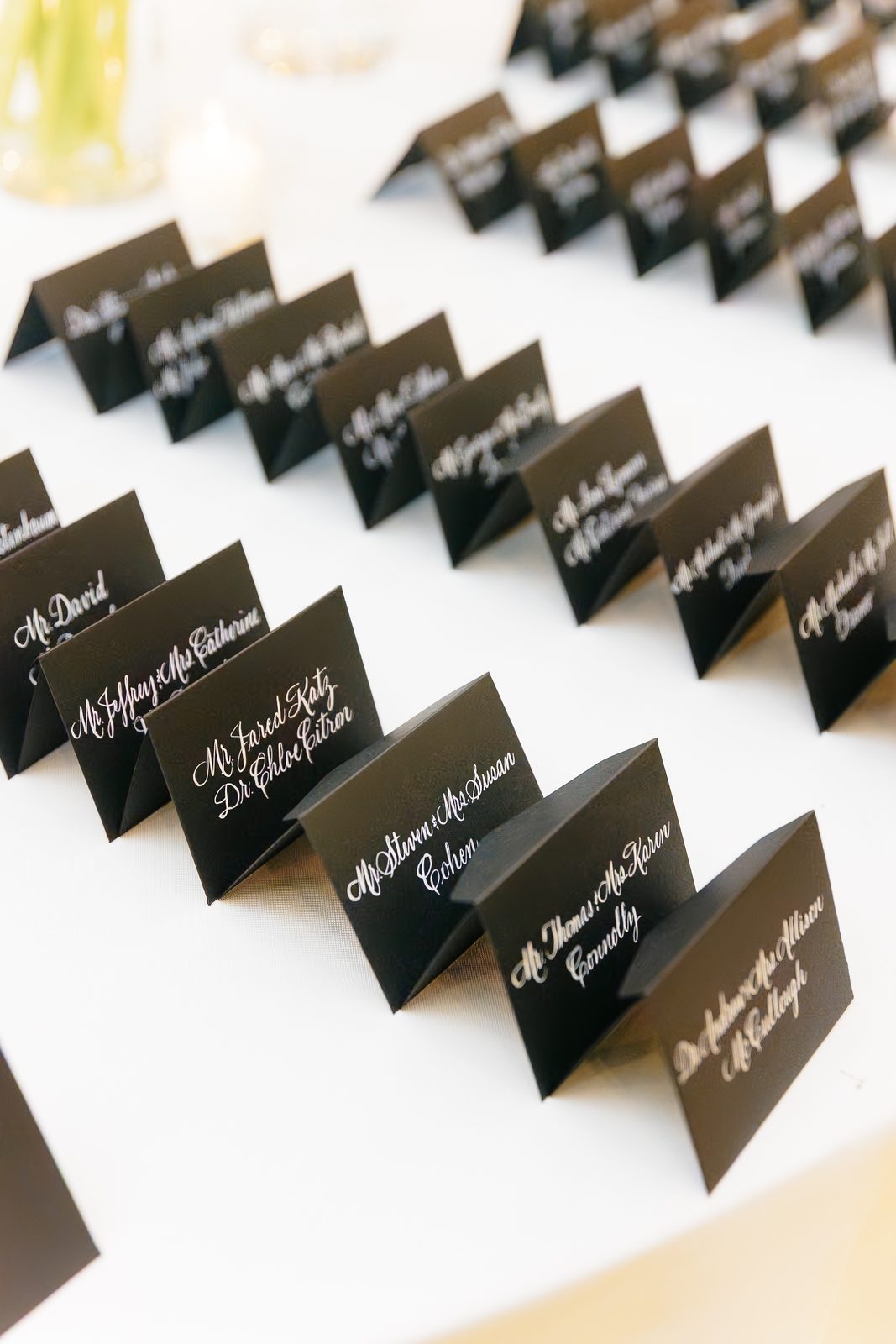 Black escort cards with white calligraphy at the reception