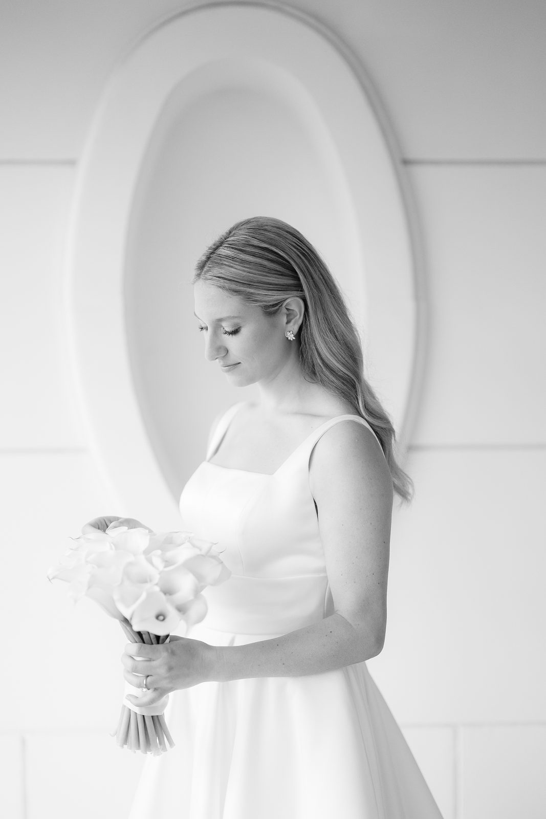 Black and white bridal portrait of Hana with calla lilies in an arched alcove